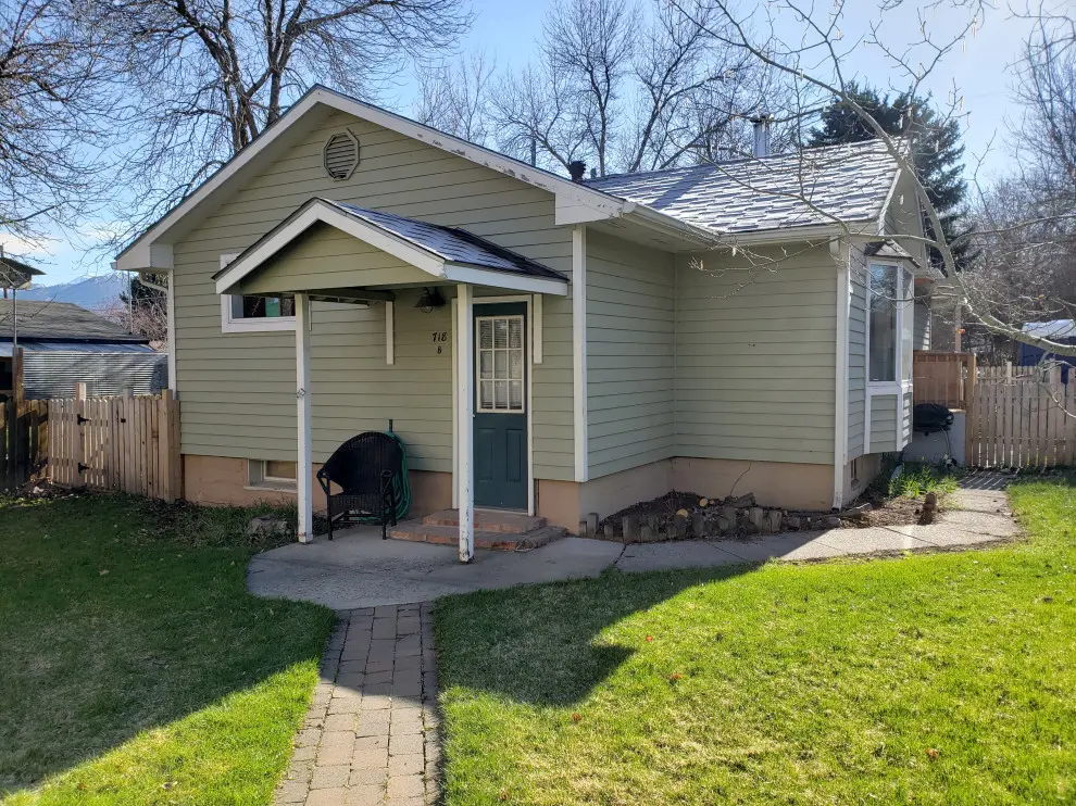 Small house with green siding and porch.